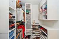 A custom built walk-in closet offers generous storage and organization.