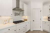 A sleek range hood and gas cooktop are perfect for the serious chef.