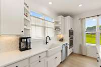 The farmhouse sink adds charm and practicality while the tile backsplash ties the space together beautifully.