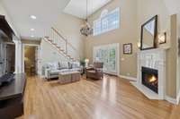 The living room has a spacious, open layout with tall, beautiful windows and a stunning chandelier that adds a touch of luxury. 2640 Chesterfield Ct. Murfreesboro, TN 37129