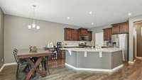 Kitchen has granite countertops, a beautiful backsplash, stainless steel appliances, a large walk-in pantry, and upgraded wood floors! And spacious dining area will fit a table for 8!