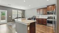 Kitchen has granite countertops, a beautiful backsplash, stainless steel appliances, a large walk-in pantry, and upgraded wood floors!