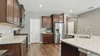 Kitchen has granite countertops, a beautiful backsplash, stainless steel appliances, a large walk-in pantry, and upgraded wood floors!