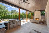 Covered porch with gorgeous limestone tile, gas fireplace and ceiling fans
