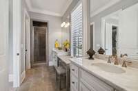 Elegant First Floor Guest Bath Features Dual Vanities, Large Shower, Walk-in Closet, and Space for a Make Up Table or Bench