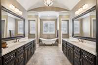This Gorgeous Primary Bedroom Bath Features Dual Vanities, a Relaxing Freestanding Claw Foot Soaking Tub, Large Shower with Bench, and Two Separate Commode Areas
