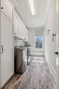 Light Filled Laundry Features Custom Cabinetry, Sink, and a Gorgeous Brick Floor