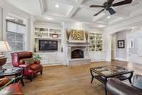 The Great Room Features Lovely Hardwood Flooring, a Coffered Ceiling, Custom Built-in Bookcases, an ArcaStone Fireplace with Unique Gas Logs, and a Bay Window that Brings in Lots of Natural Light.