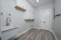 Large laundry room with many cabinets and sink!