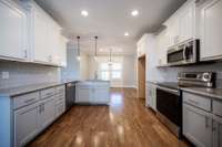 Lovely kitchen with stainless appliances, granite counters and tile backsplash.