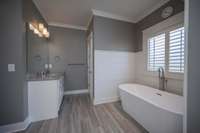 Ship lap surrounds this stand alone soaking tub in the primary bath.