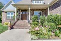 Step onto this lovely covered front porch overlooking this corner lot.