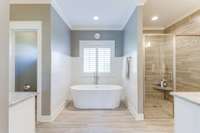 A curbless entry shower, soaking tub and 2 separate granite vanities are just a few of the amenities in this tiled primary bathroom!