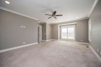 Very large primary bedroom with lots of light streaming through the large windows with plantation shutters!