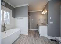 Tile floors and granite counters along with 2 separate vanities and a walk-in stand alone shower complete this lovely bath!