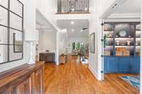 As you enter, you're welcomed by rich hardwood floors, soaring ceilings, custom built-in shelving, and striking ironwork.