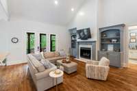 The spacious living room is thoughtfully designed with custom built-ins and seamless access to the outdoor patio through large glass doors—perfect for entertaining or relaxing in style.