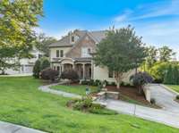 Nestled on a spacious lot, this charming home is surrounded by mature trees, vibrant green lawns, and carefully designed landscaping.