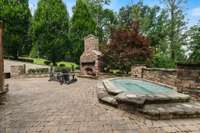 Relax and unwind in the outdoor spa while enjoying the warmth and ambiance of the adjacent fireplace—creating the perfect backyard retreat.