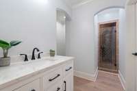 The downstairs bathroom features a sleek, modern design with clean lines and contemporary fixtures.