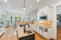 Designed for both everyday living and entertaining, the kitchen features ample counter space and multiple avenues for cooking, baking, or hosting.