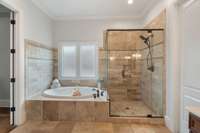 Richly styled with Tuscany-inspired tile, the spa-like ensuite features a deep soaking tub and a sleek glass-enclosed walk-in shower for ultimate relaxation.