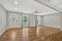 The living room features large windows and hardwood floors!