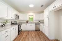 Stunning Kitchen with New Kitchen Cabinets and Hardware, New Stainless Steel Appliances, Granite Countertops, and updated lighting.
