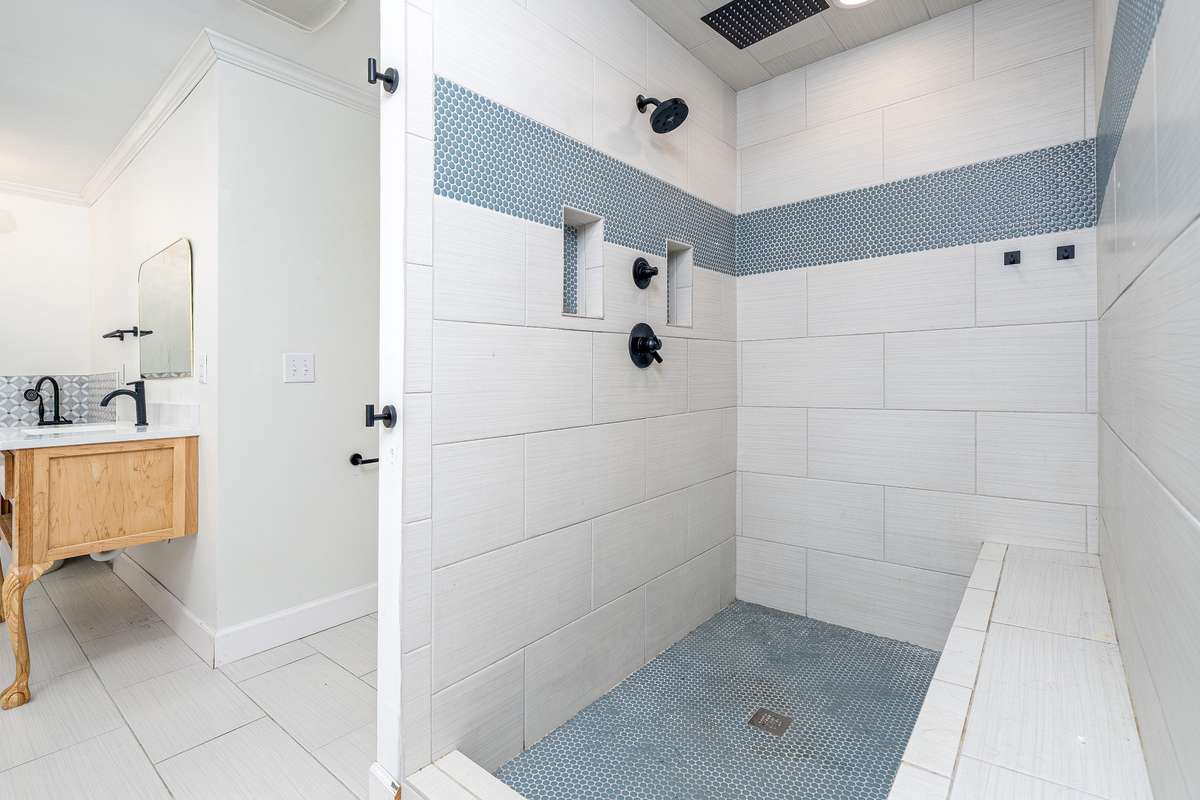 Oversized tiled stand up shower with bench