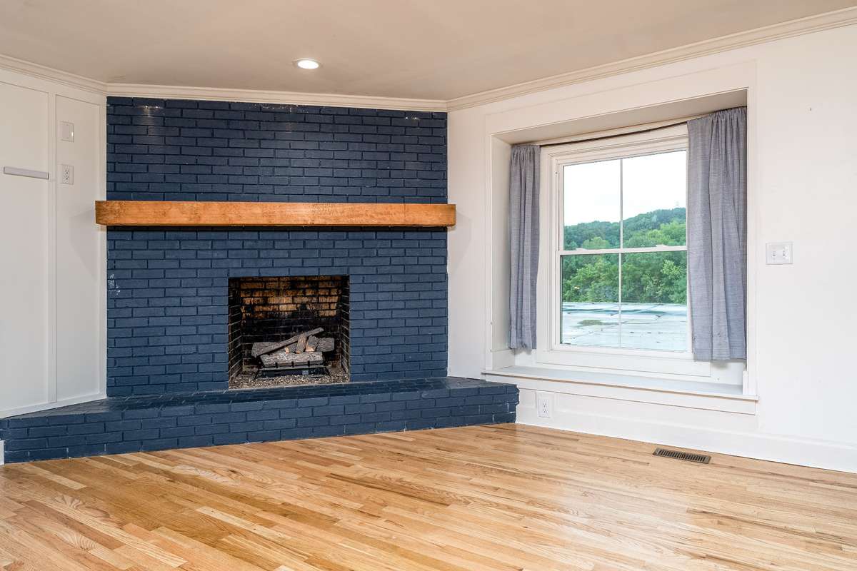 Brick Fireplace with wooden beam mantle and gas logs