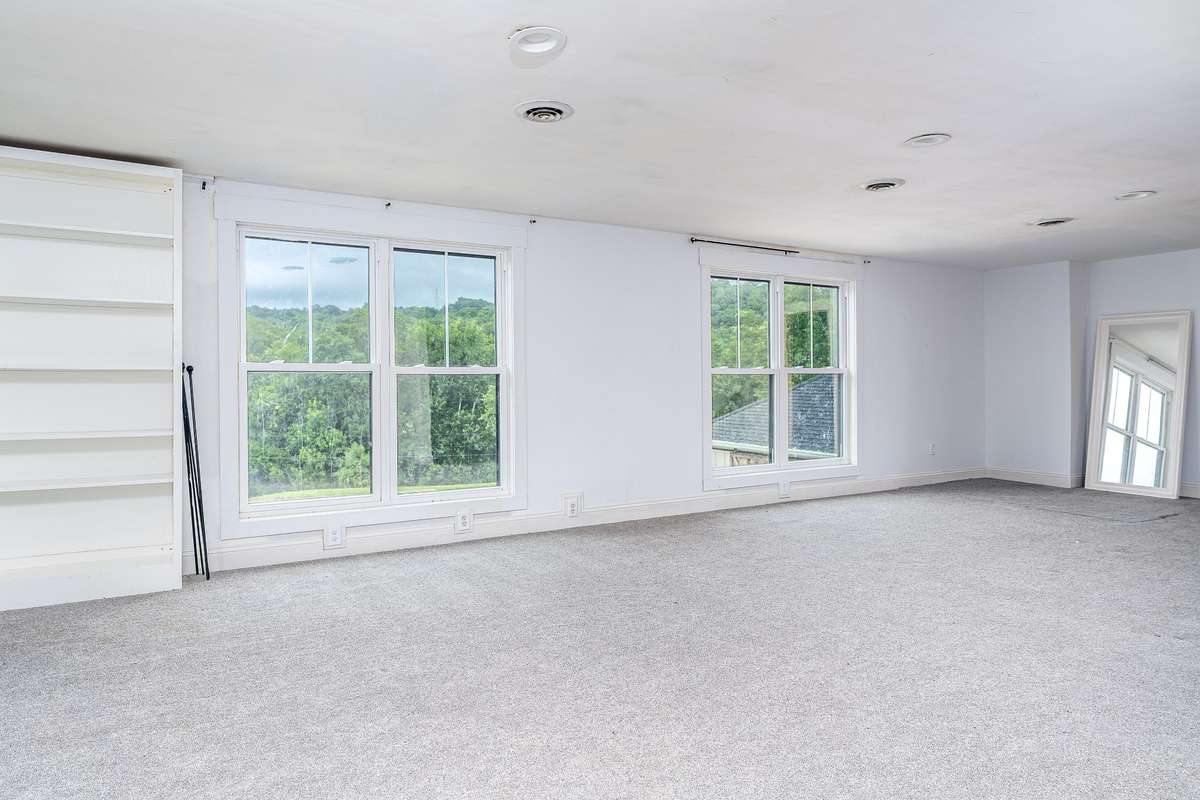 Another view of the Upstairs Bedroom with double windows and a built in bookcase
