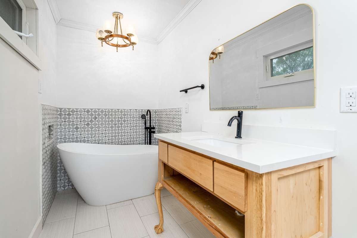Primary Bathroom with soaking tub and tiled floor and surround wall