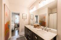 The shared bath between two bedrooms has dual sinks and a marble vanity more than 85 inches long. The water closet is private.