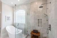 The shower features a handheld and rain head