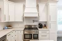 Large European gas range with double oven, new cabinets, pot filler and plenty of drawers.