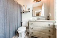 Private bath with granite top vanity and chevron tile