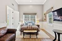 Detached pool house features crown molding, window treatments, and wainscotting