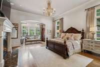 Primary suite features hardwood floors, custom drapery, designer lighting and finishes, gas fireplace and sitting area