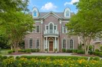 So much attention to detail with beautiful trim, arched windows, extensive pavers and stunning landscaping.