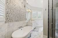 This beautiful bathroom was thoughtfully designed with custom tile features, lighting and step in shower!