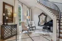 Entry way with curved stairway and sitting area is so inviting!