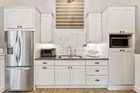 Kitchen in pool house has microwave, SS refrigerator, custom tile and cabinets