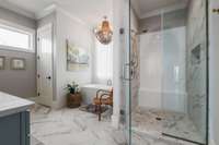 The primary bathroom exudes luxury with a striking walk-in shower, elegant freestanding tub, dual vanities, and a generously sized custom walk-in closet.
