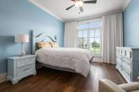 The secondary main-floor bedroom is generously sized and offers beautiful views, making it a comfortable and inviting retreat for guests and family.