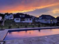 Welcome to serene sunset evenings around this stunning pool—where every night feels like a getaway.