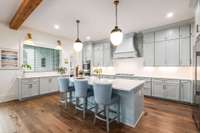 The chef’s kitchen boasts elegant quartz countertops and custom cabinetry that extends to the ceiling, offering both elevated style and extra storage.