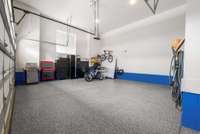 The garage offers three bays (with two shown), complete with a brand-new custom epoxy floor that adds both durability and polished style.