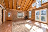 Front Entry Door and floor to ceiling windows with exposed log walls