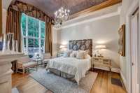 The primary suite includes two complete primary baths, a limestone fireplace mantel with gas logs, a barrel ceiling and a 12' window wall.
