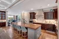 The custom Tennessee limestone vent hood accents this amazing gourmet kitchen along with the Artistic Tile backsplash.